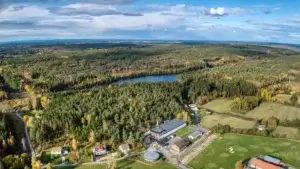 Dronebilde av vannverket med vann i en skog i bakgrunnen