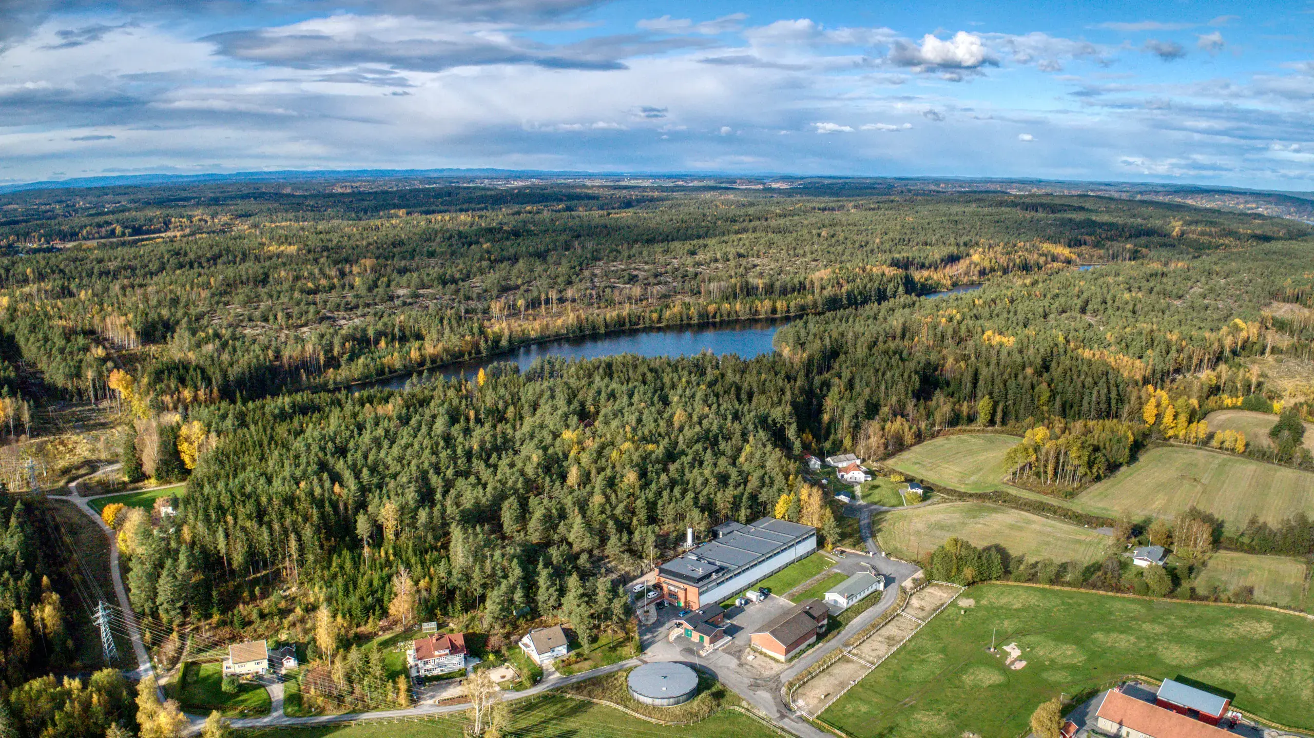 Dronebilde av vannverket med vann i en skog i bakgrunnen
