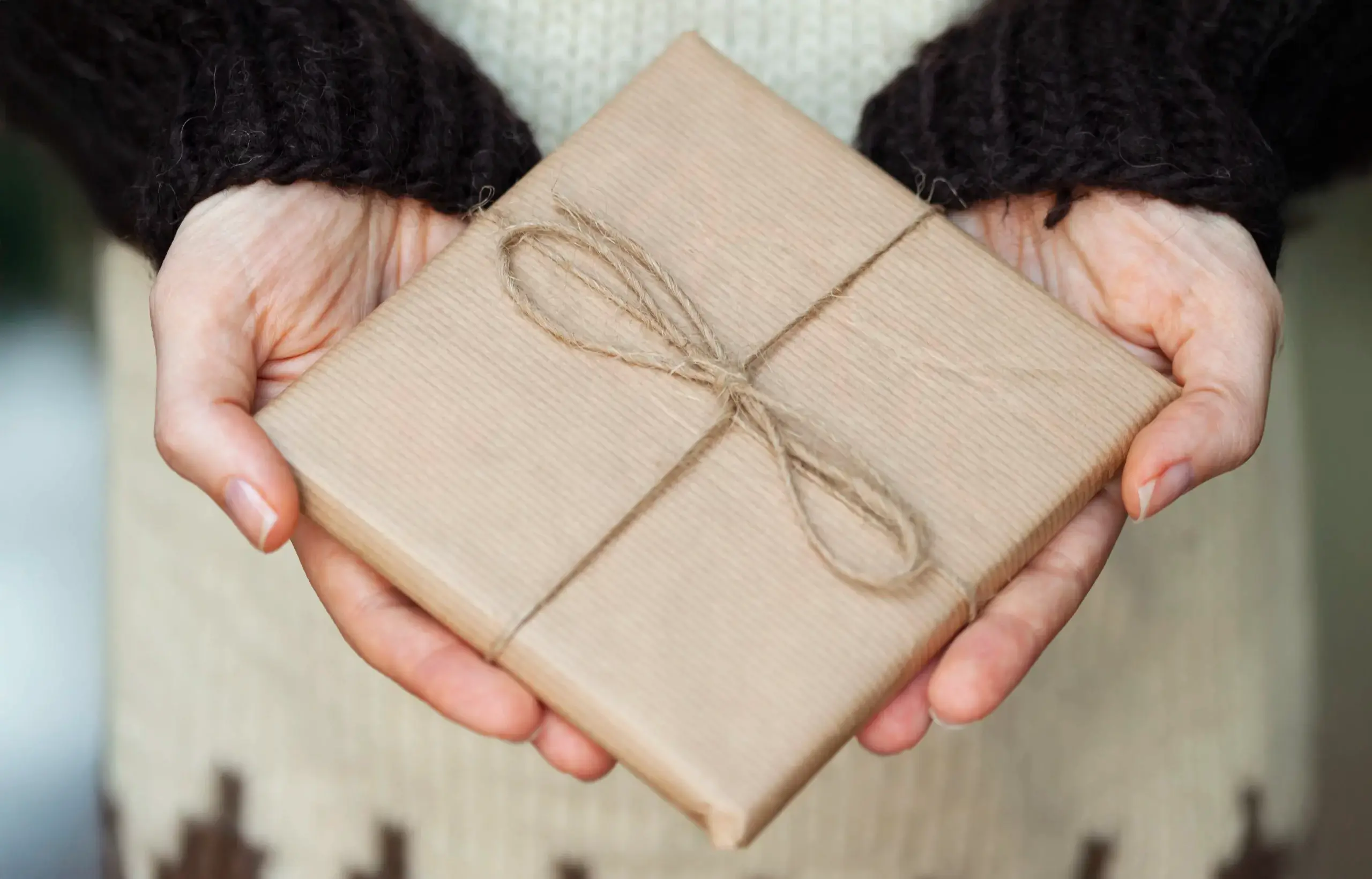 En person holder en miljøvennlig innpakket presang.