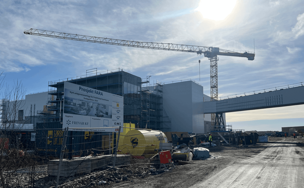 Byggeplass med FARA renseanlegg under oppføring. Byggeslikt i forkant og byggekran over bygget.