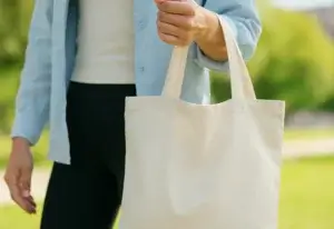 Kvinne som bærer på en pose laget av bomull