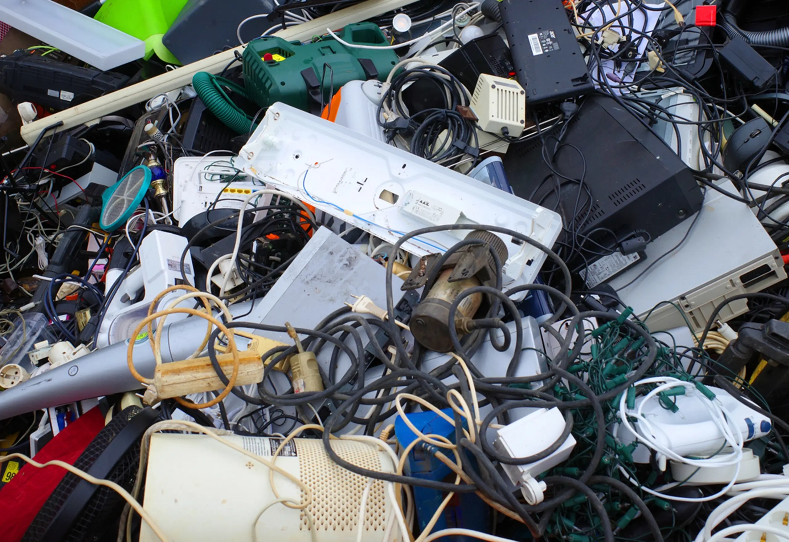 En haug med kasserte elektriske apparater og ledninger, som illustrerer elektronisk avfall.