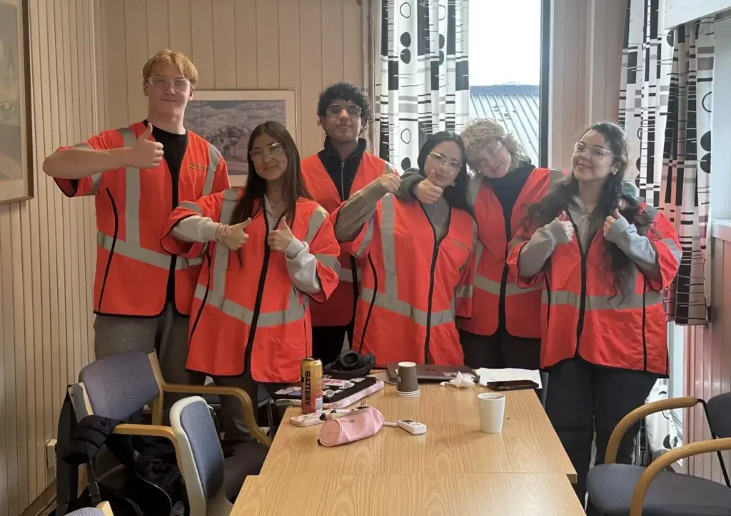 Elever fra Greåker VGS' science-linje med oransje synlighetsvester er på besøk hos FREVAR.